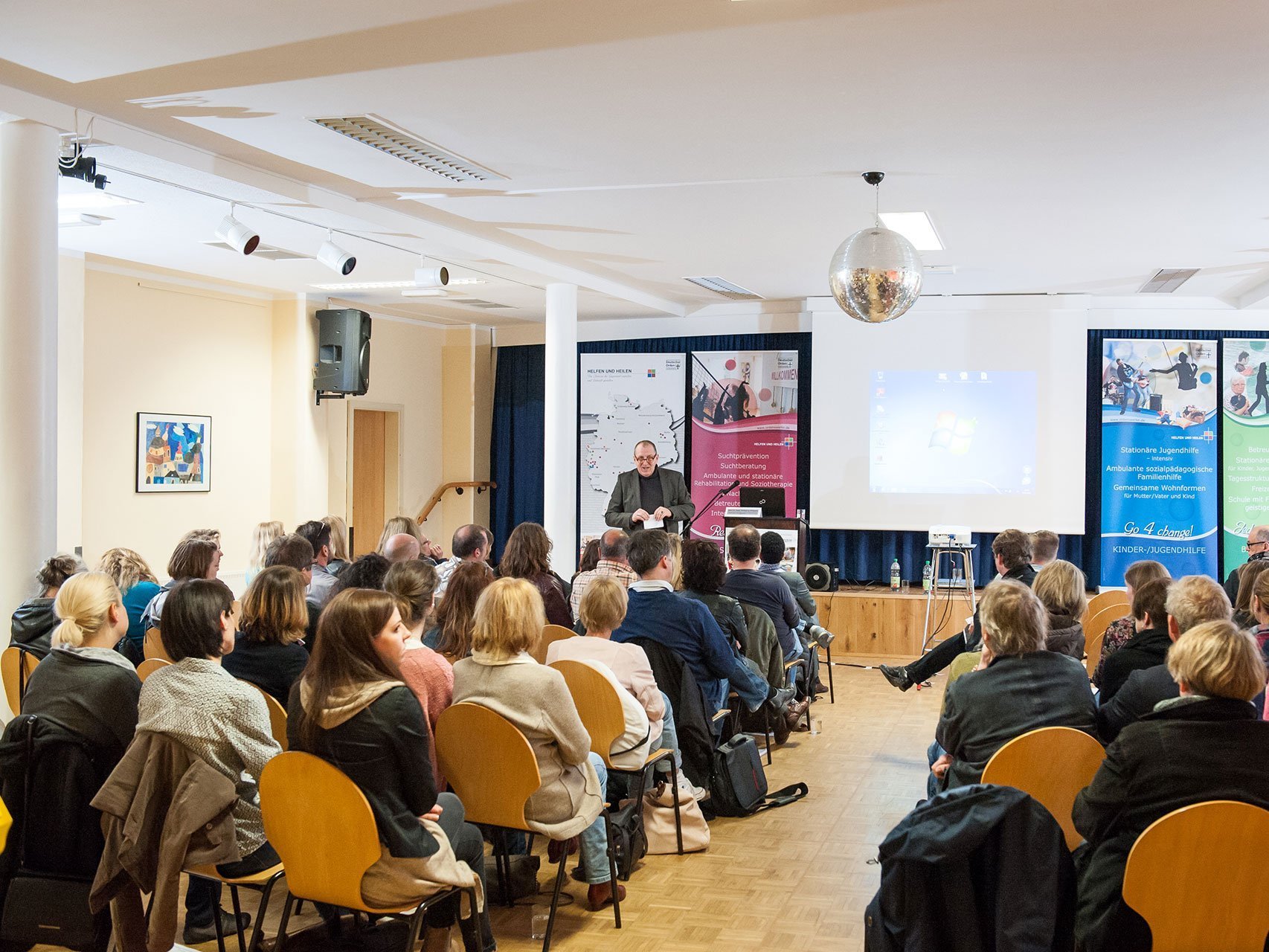 Vortrag in einem kleinen Saal: viele Besucher lauschen dem Sprecher