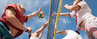 Beach-Volleball: der Ball wird gerade über das Netz geschlagen