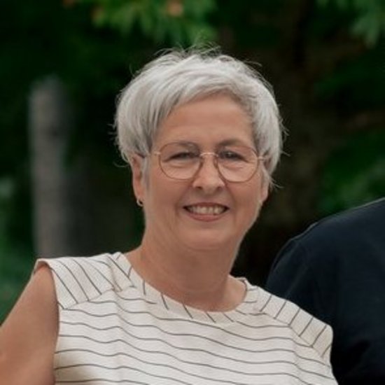 Andrea Gofferje Gruppenfoto von sechs Personen, die nebeneinander im Freien stehen und in die Kamera lächeln. Im Hintergrund sind Bäume und ein Haus zu erkennen.