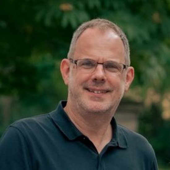 Michael Vogel Gruppenfoto von sechs Personen, die nebeneinander im Freien stehen und in die Kamera lächeln. Im Hintergrund sind Bäume und ein Haus zu erkennen.